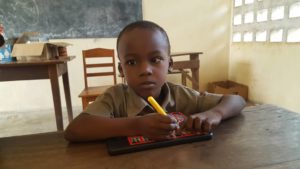 Bambino non vedente del Togo che scrive in braille con tavoletta a lettura diretta, senza ribaltamento, da noi costruita