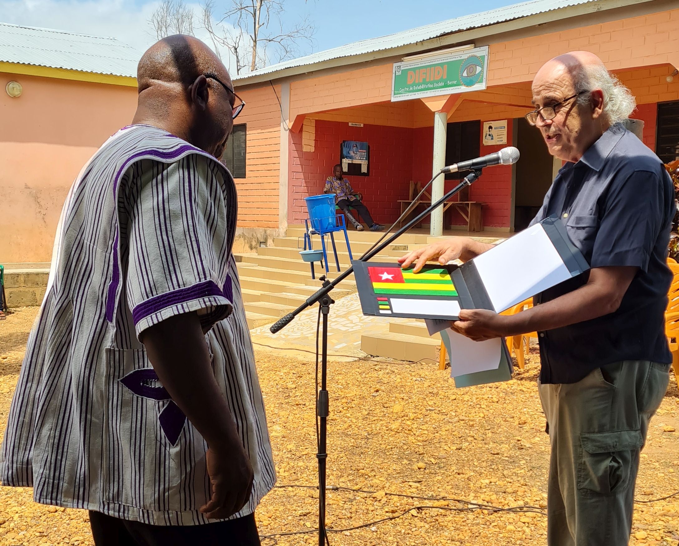 Alla fine del suo intervento Flavio consegna al prefetto di Bassar una copia della bandiera del Togo tattile prodotta dalla nostra associazione